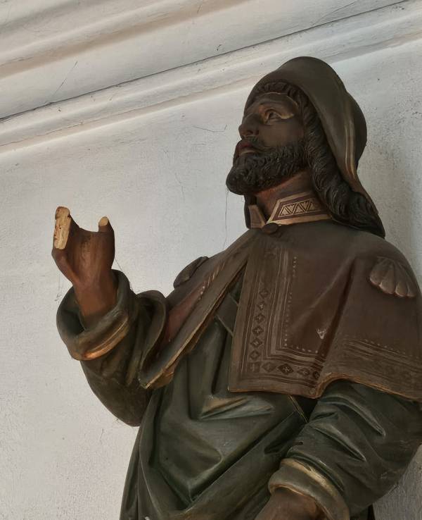 Eine Figur hält eine Hand hoch, an der alle Finger abgebrochen sind.