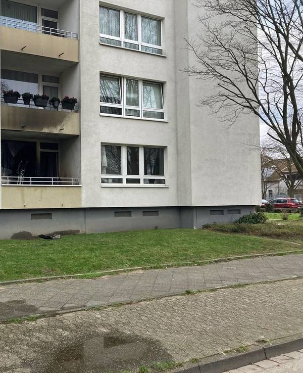 An einem Mehrfamilienhaus ist Ruß an der Fassade zu sehen.