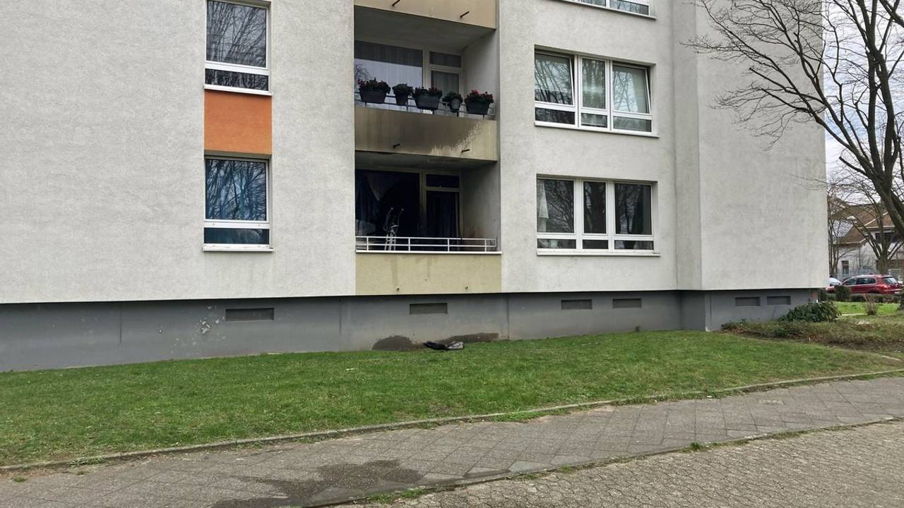 An einem Mehrfamilienhaus ist Ruß an der Fassade zu sehen.