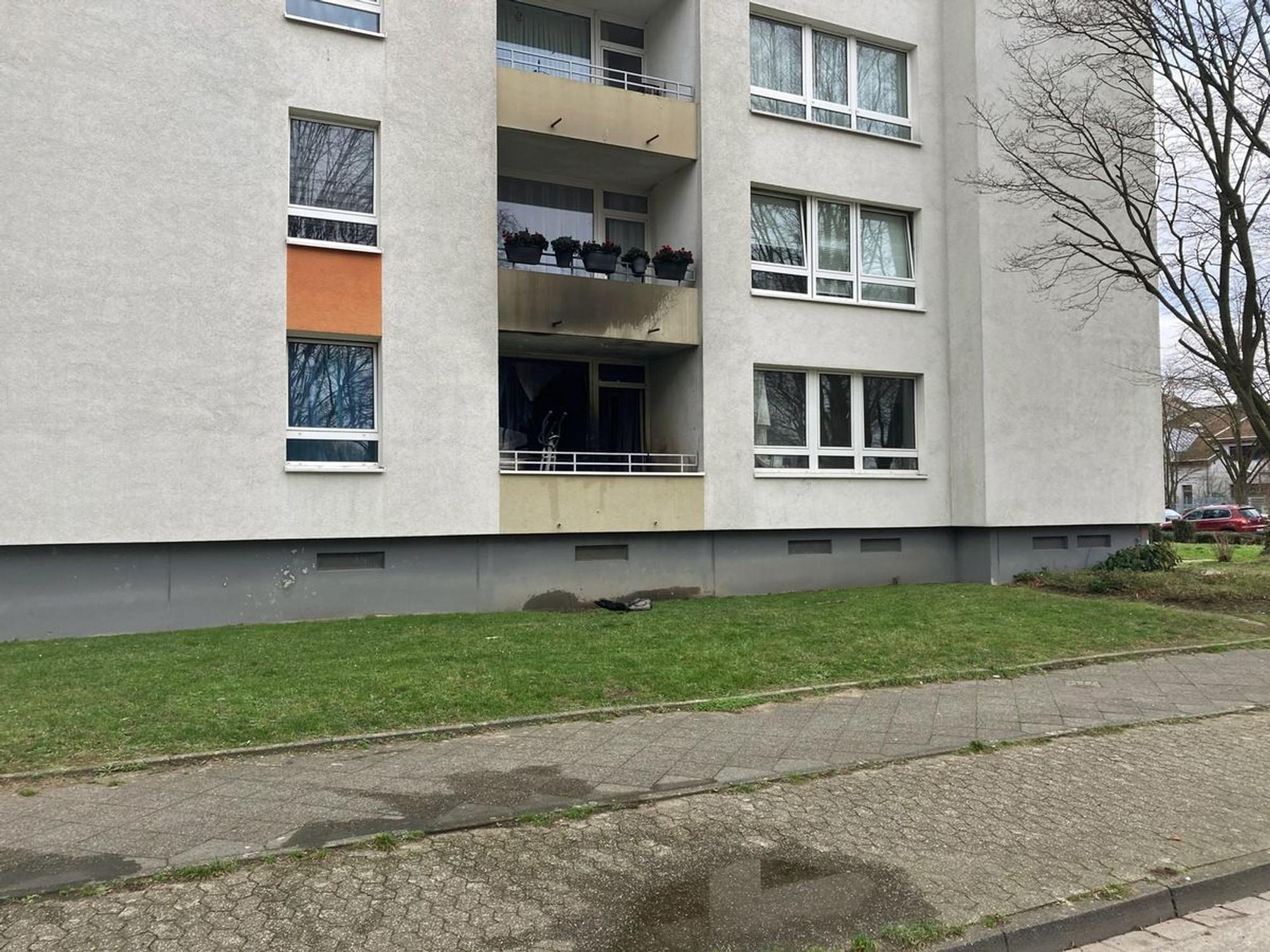 An einem Mehrfamilienhaus ist Ruß an der Fassade zu sehen.