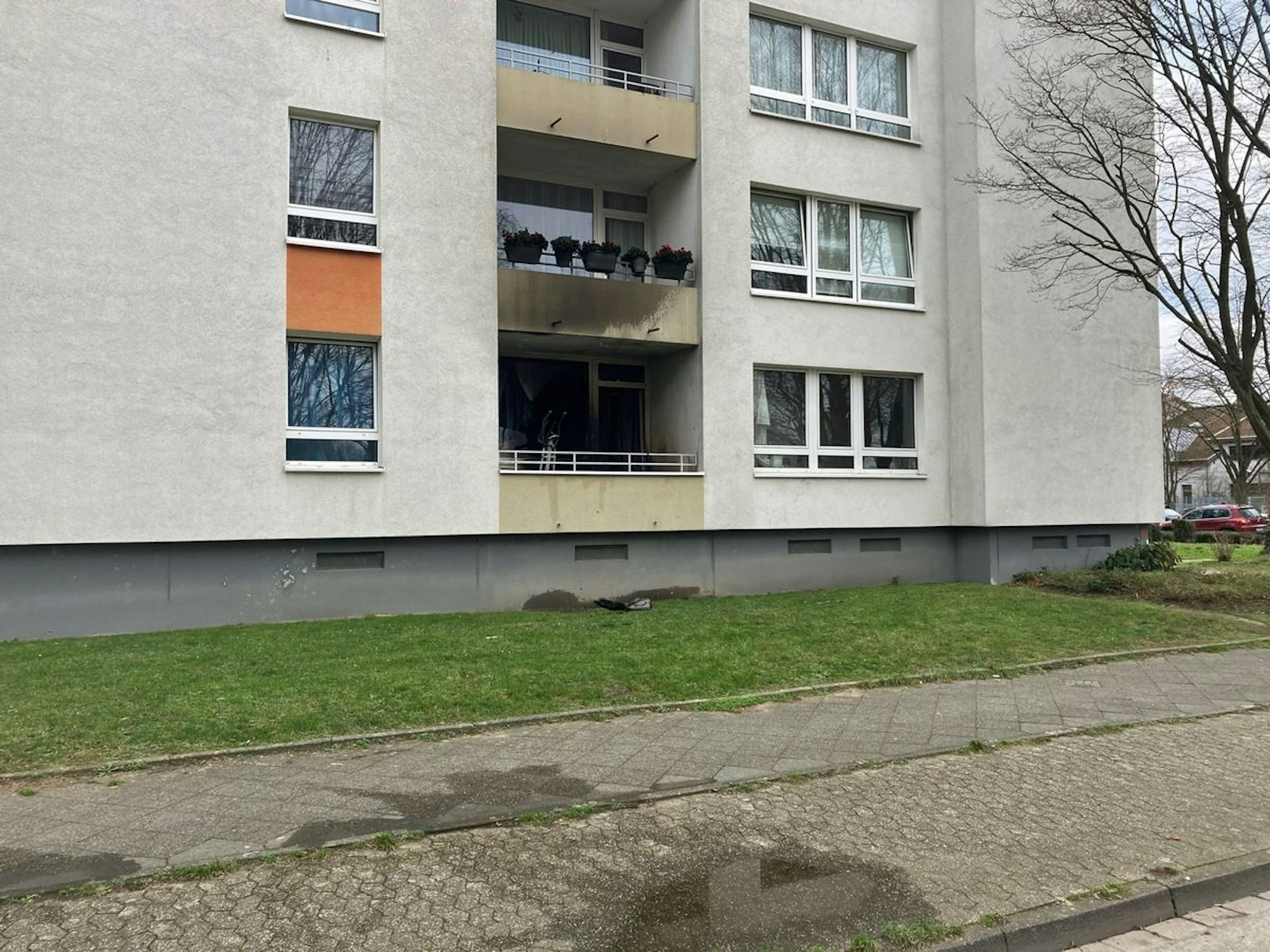 An einem Mehrfamilienhaus ist Ruß an der Fassade zu sehen.