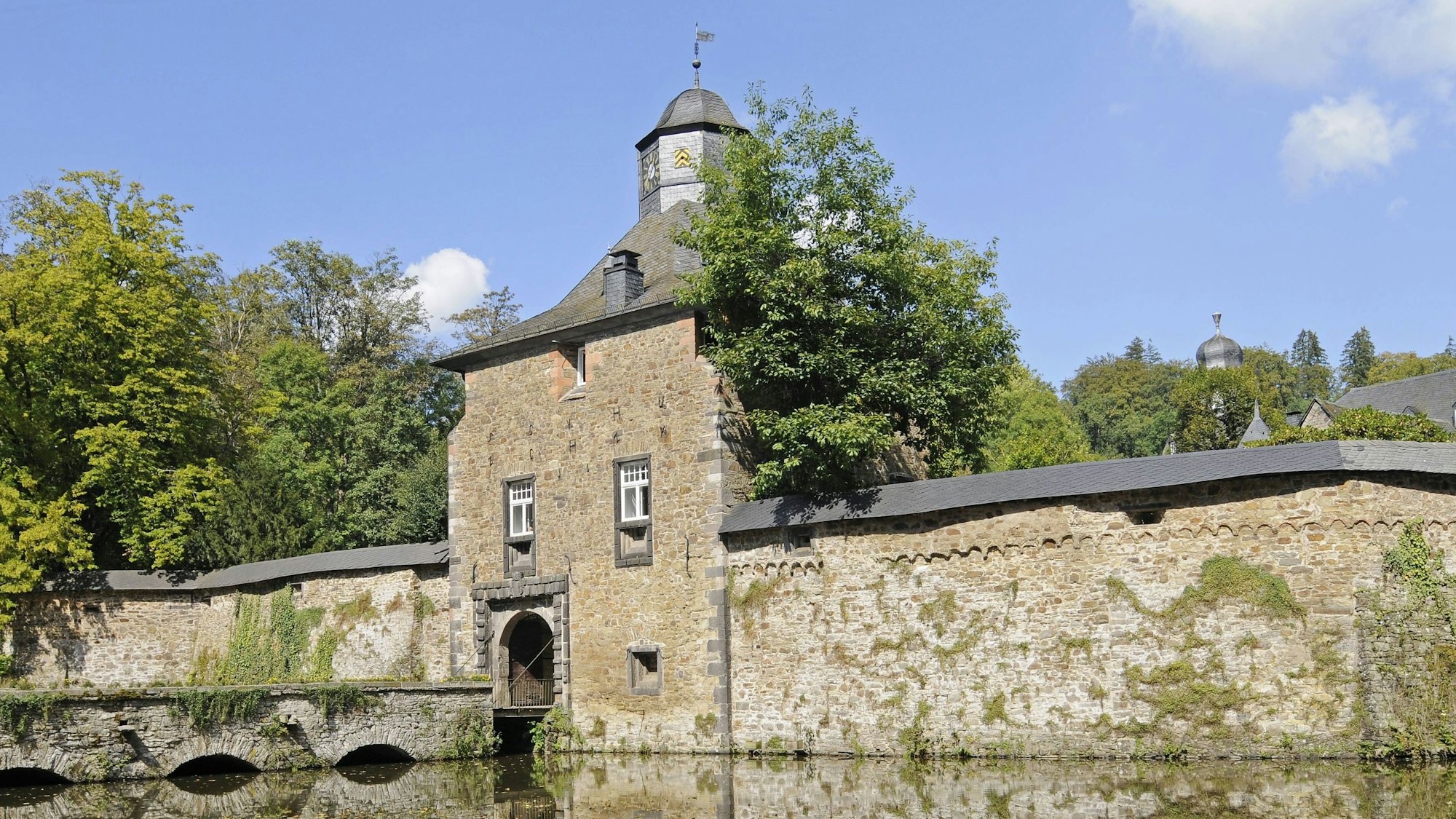 Ein Wasserschloss aus Bruchsteinen mit Schiefertürmen