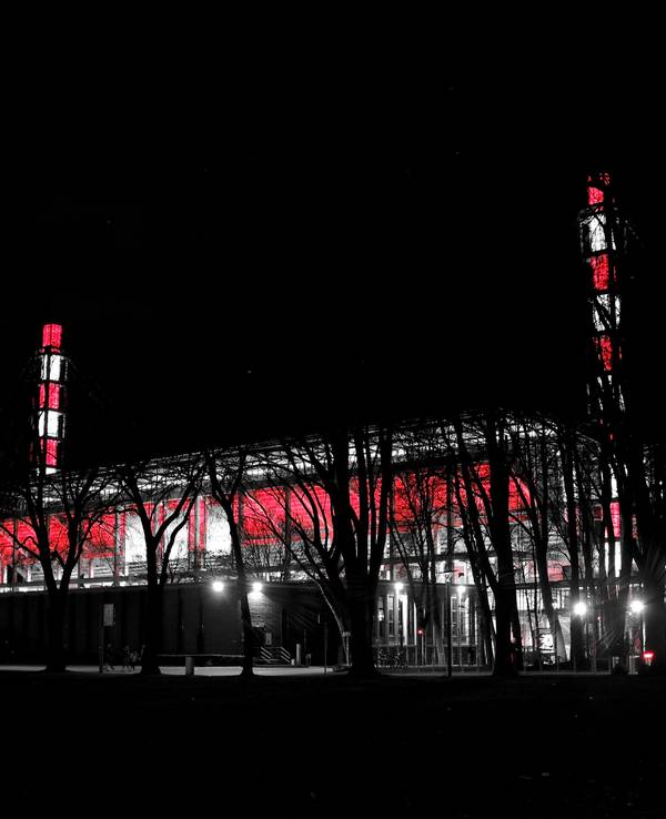 Das Stadion des 1. FC Köln leuchtet bei Nacht in rot und weiß.