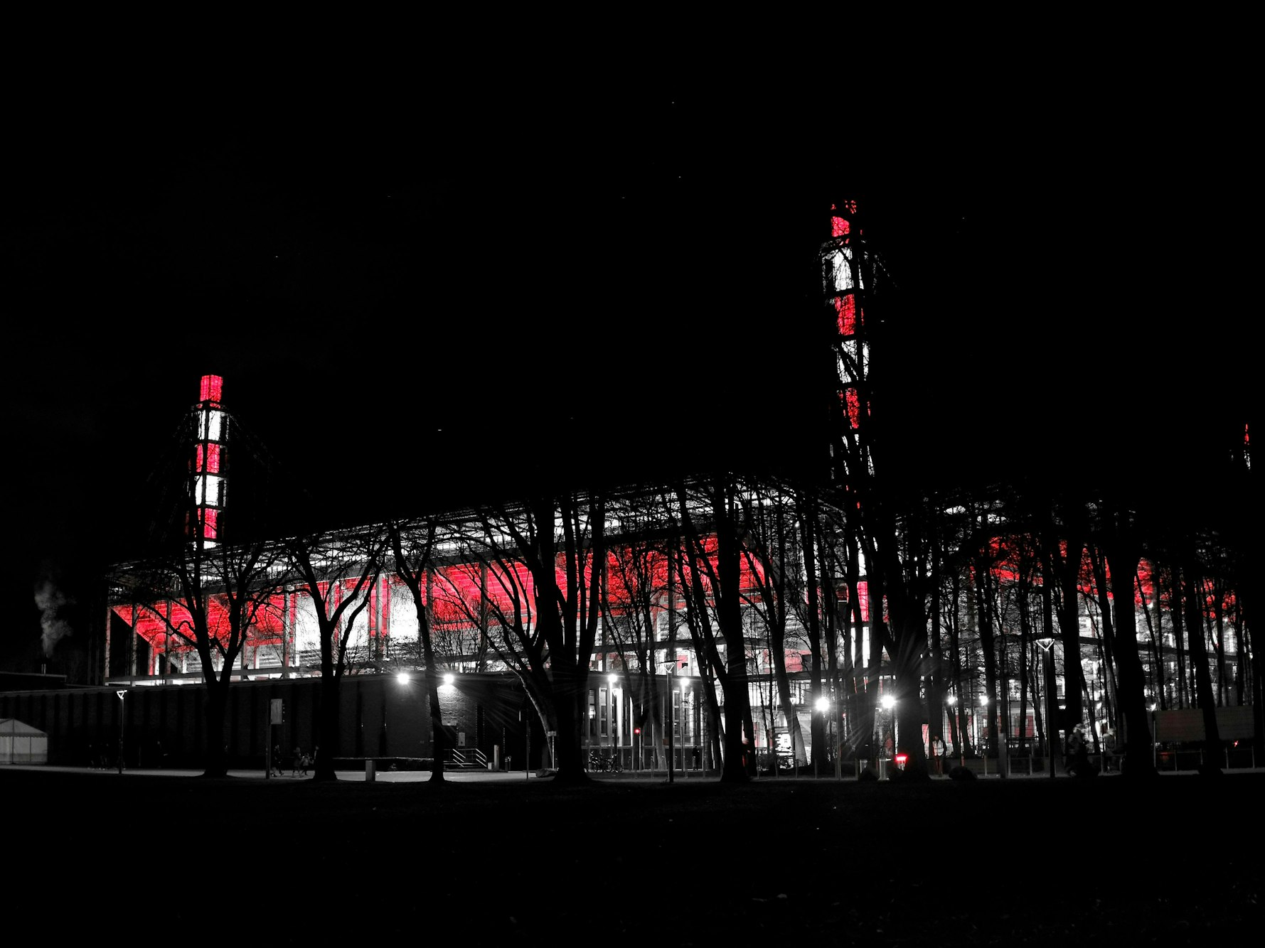 Das Stadion des 1. FC Köln leuchtet bei Nacht in rot und weiß.