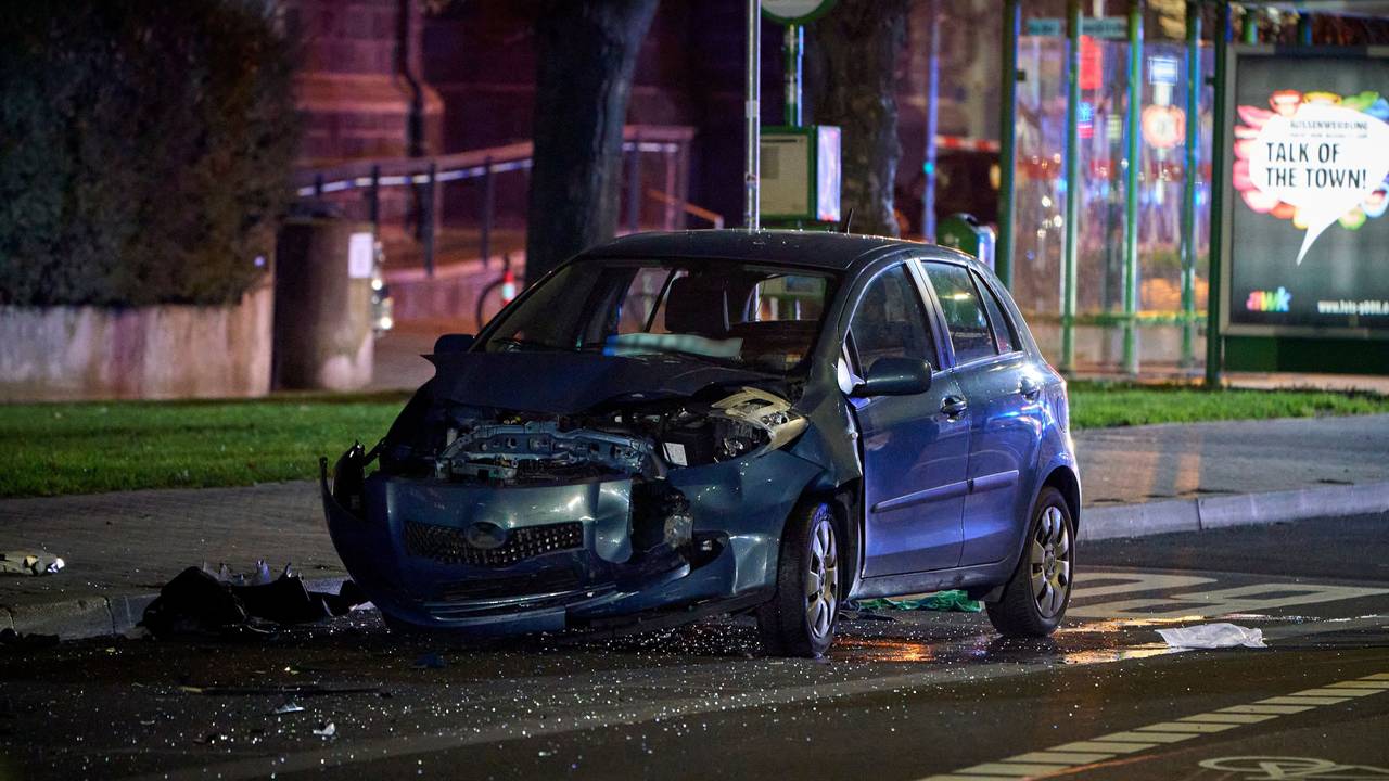 Ein beteiligtes Fahrzeug steht an der Unfallstelle, in der Nähe einer Bushaltestelle. Ein Mann verletzt mit einem Auto in Gießen mehrere Menschen.