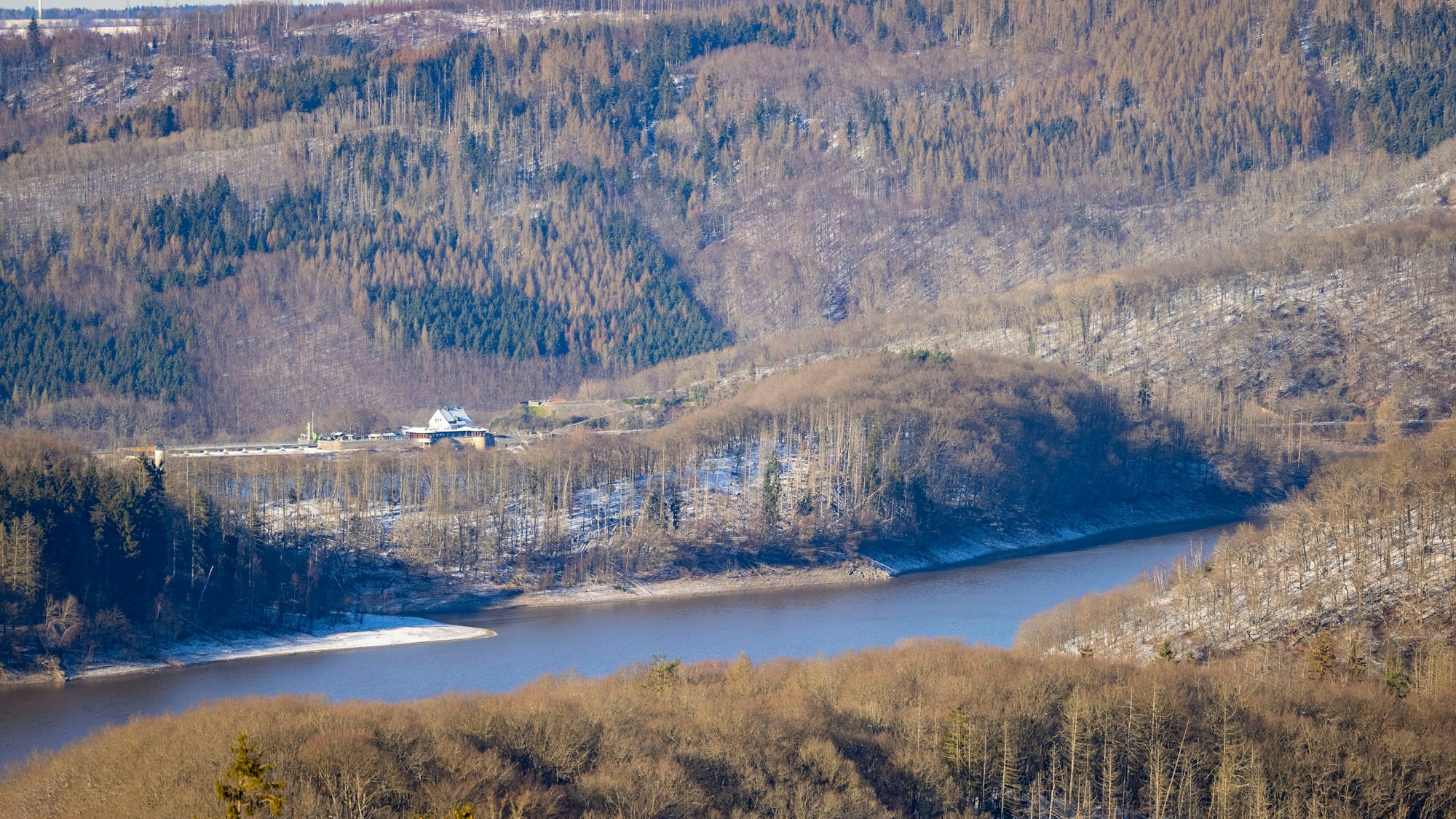 Der Rursee in der Eifel zwischen bewaldeten Hängen.