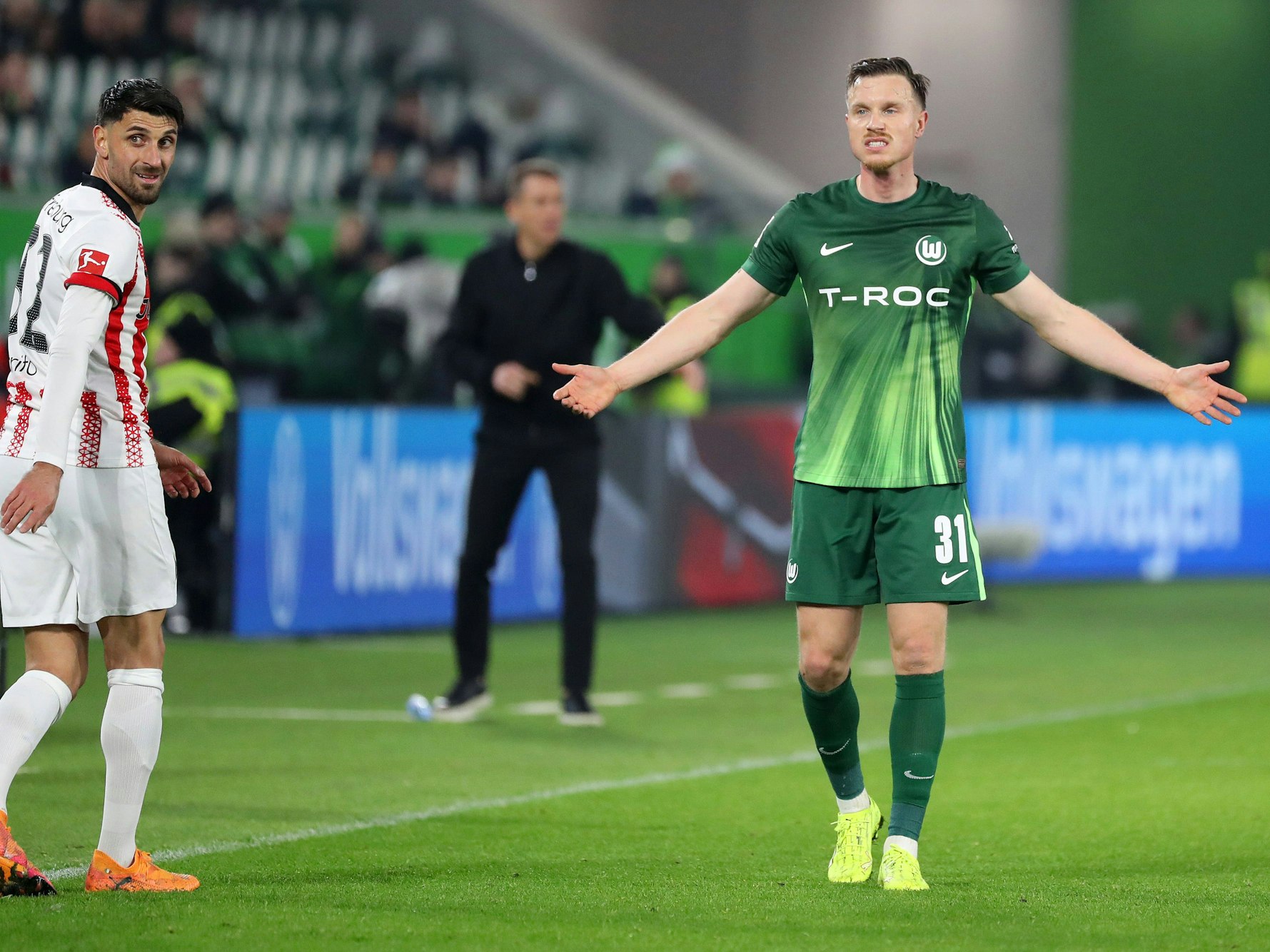 Yannick Gerhardt breitet die Hände aus, am linken Bildrand blickt Vinzenco Grifo nach hinten.