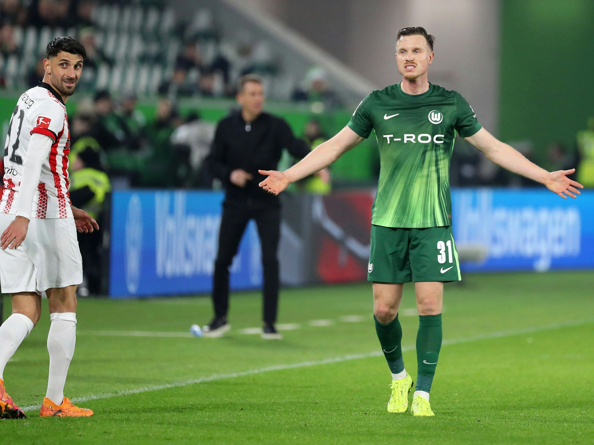 Yannick Gerhardt breitet die Hände aus, am linken Bildrand blickt Vinzenco Grifo nach hinten.