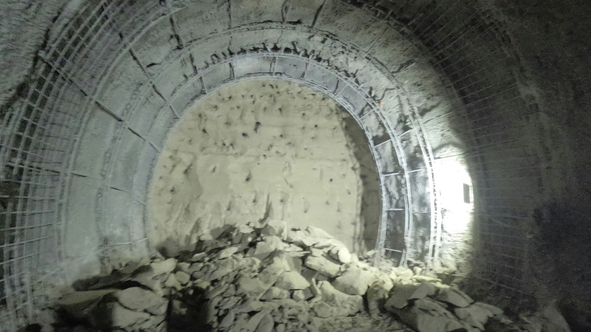 Unterirdischer Tunnel mit Gewölbe und Haufen von Gestein