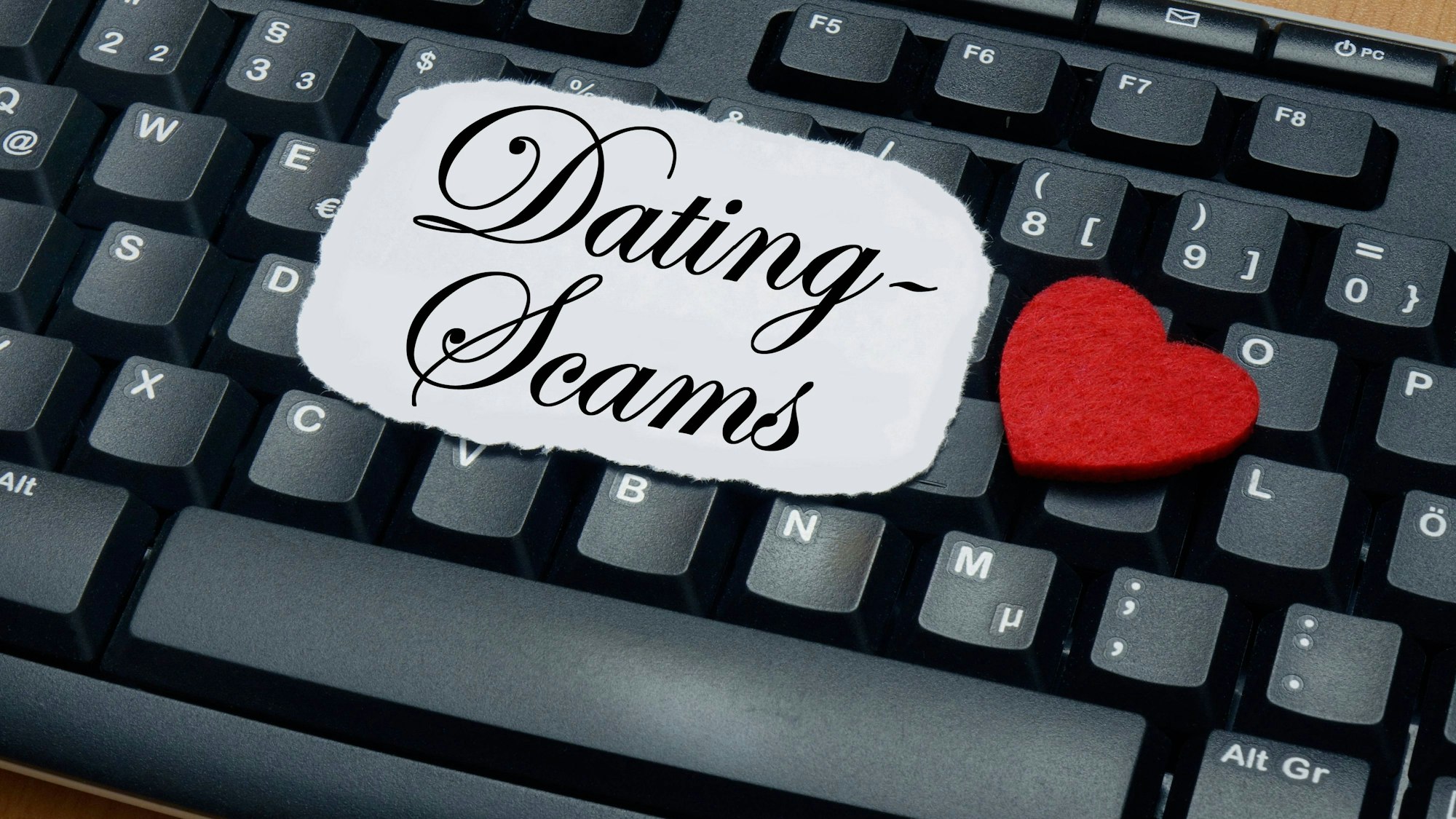 Tastatur mit Schriftzug „Dating Scams“ und Herz