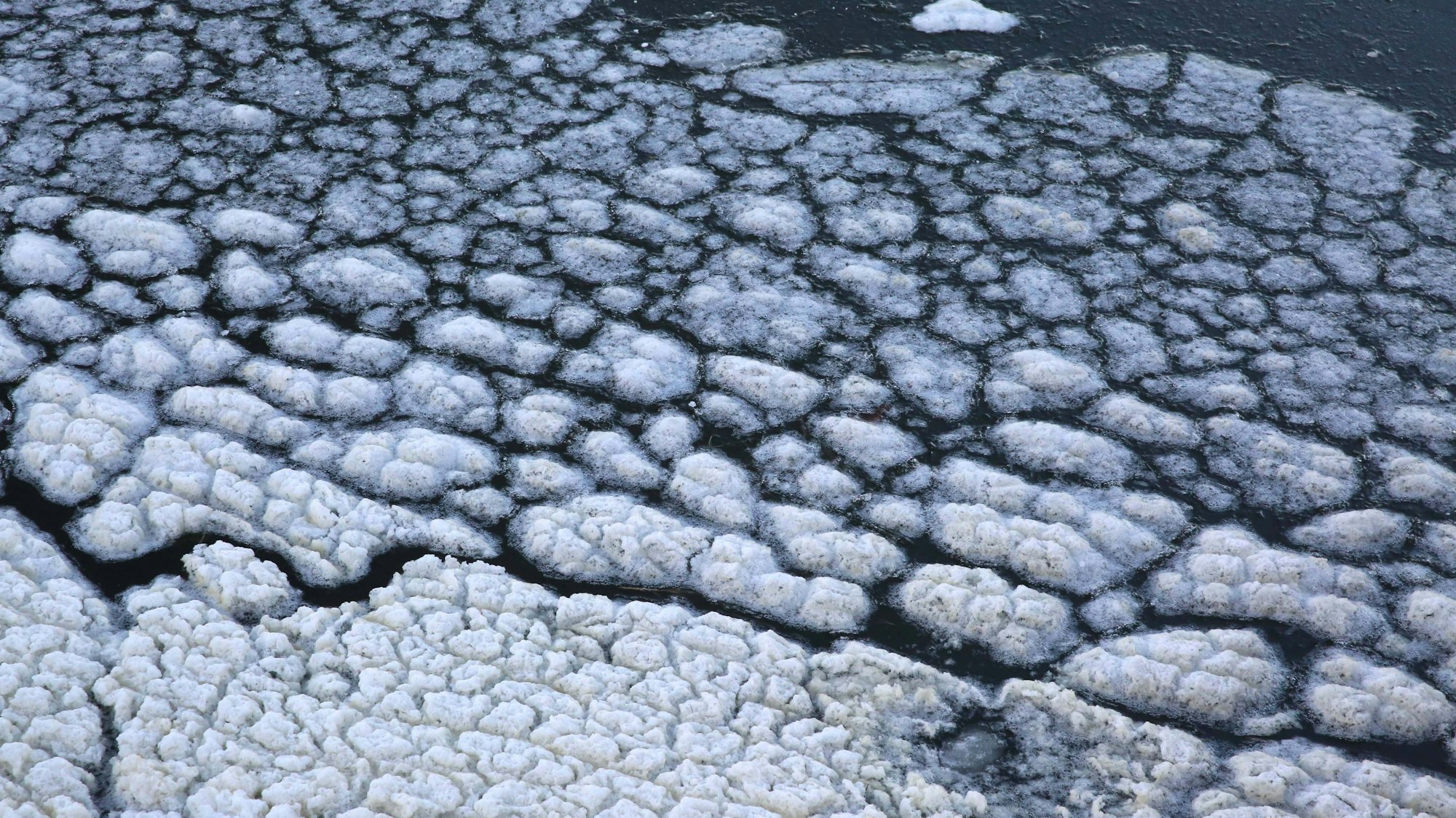 Eisformationen auf dunklem Wasser