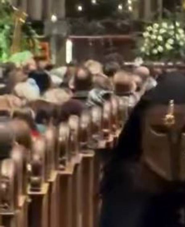 Ein Domschweizer bringt einen Störer im Kölner Dom nach draußen.