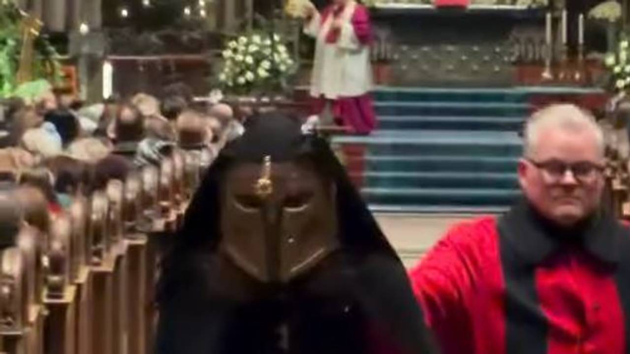 Ein Domschweizer bringt einen Störer im Kölner Dom nach draußen.