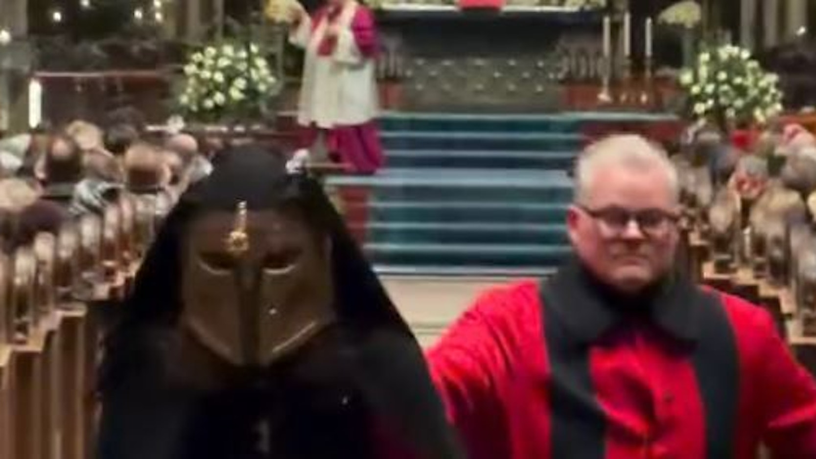 Ein Domschweizer bringt einen Störer im Kölner Dom nach draußen.