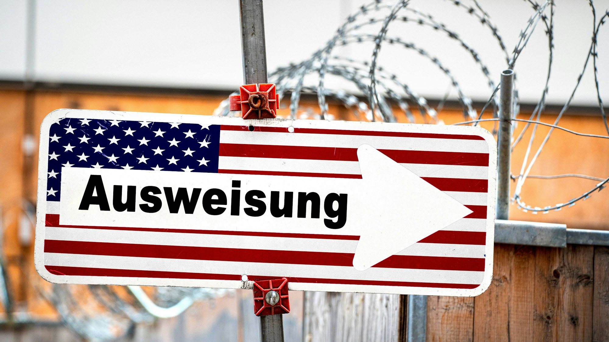 Schild mit US-Flagge, „Ausweisung“ und Stacheldraht