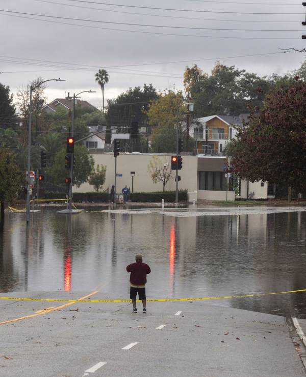 Ein Mann blickt auf eine überflutete Kreuzung im Stadtteil South Pasadena von Los Angeles.