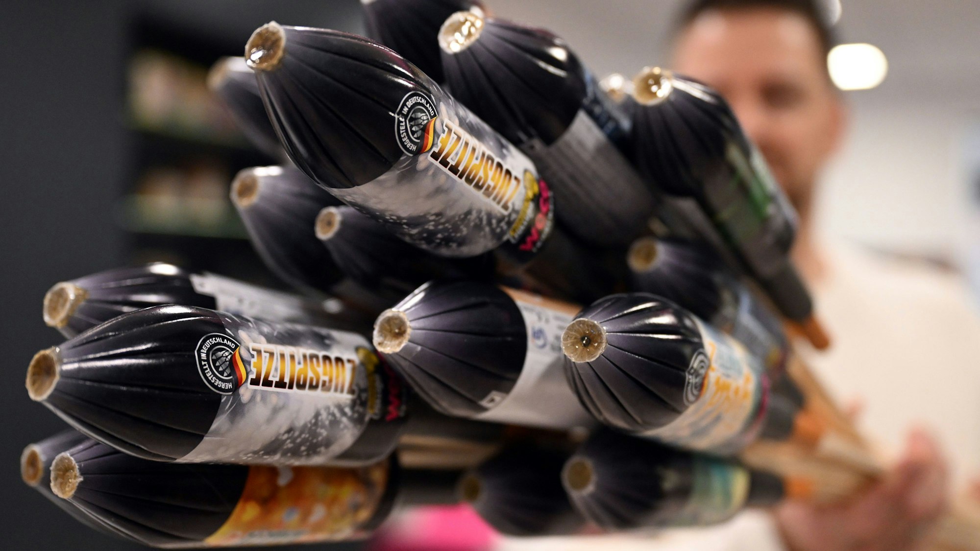 Ein Mitarbeiter hält im Showroom der Feuerwerksfirma Weco Silvesterraketen. Die Feuerwerksfirmen haben dem Handel in diesem Jahr so viel Böller, Raketen und Feuerwerksbatterien geliefert wie noch nie. (Archivbild)