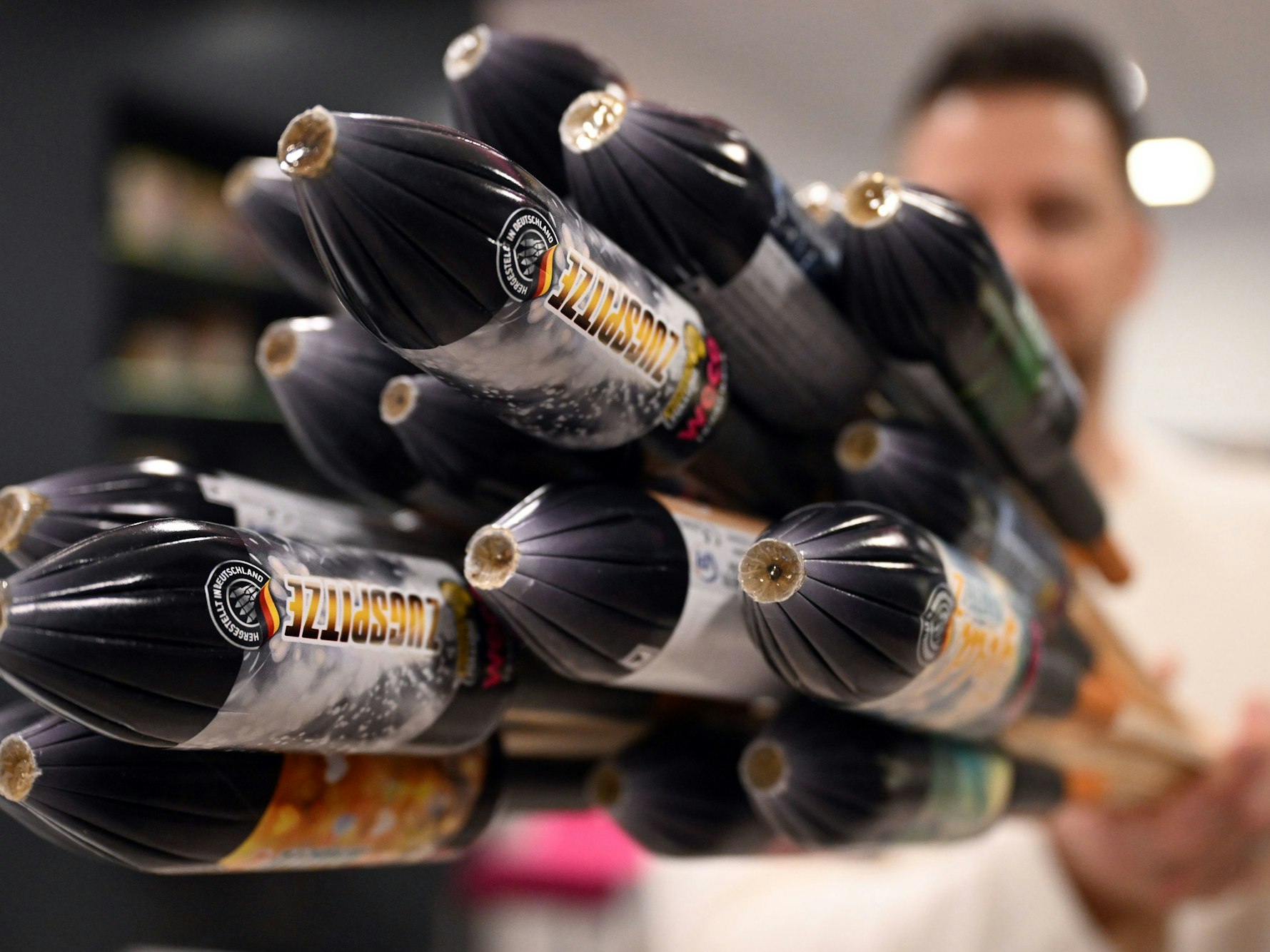 Ein Mitarbeiter hält im Showroom der Feuerwerksfirma Weco Silvesterraketen in die Kamera.