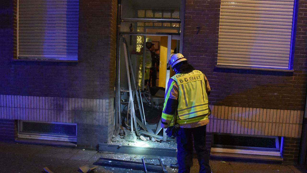 Ein Feuerwehrmann steht an der zerstörten Eingangstür.