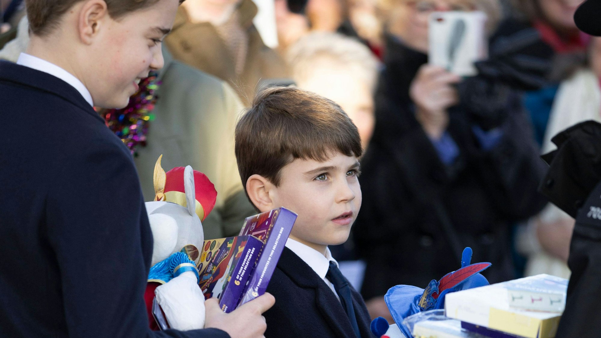 Prinz George und Prinz Louis nehmen Geschenke an.
