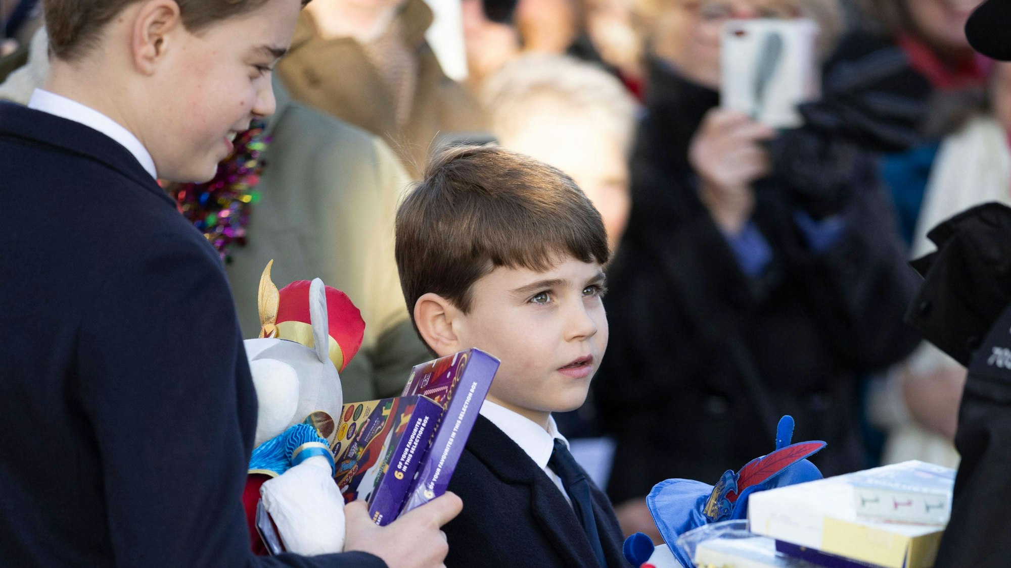 Prinz George und Prinz Louis nehmen Geschenke an.