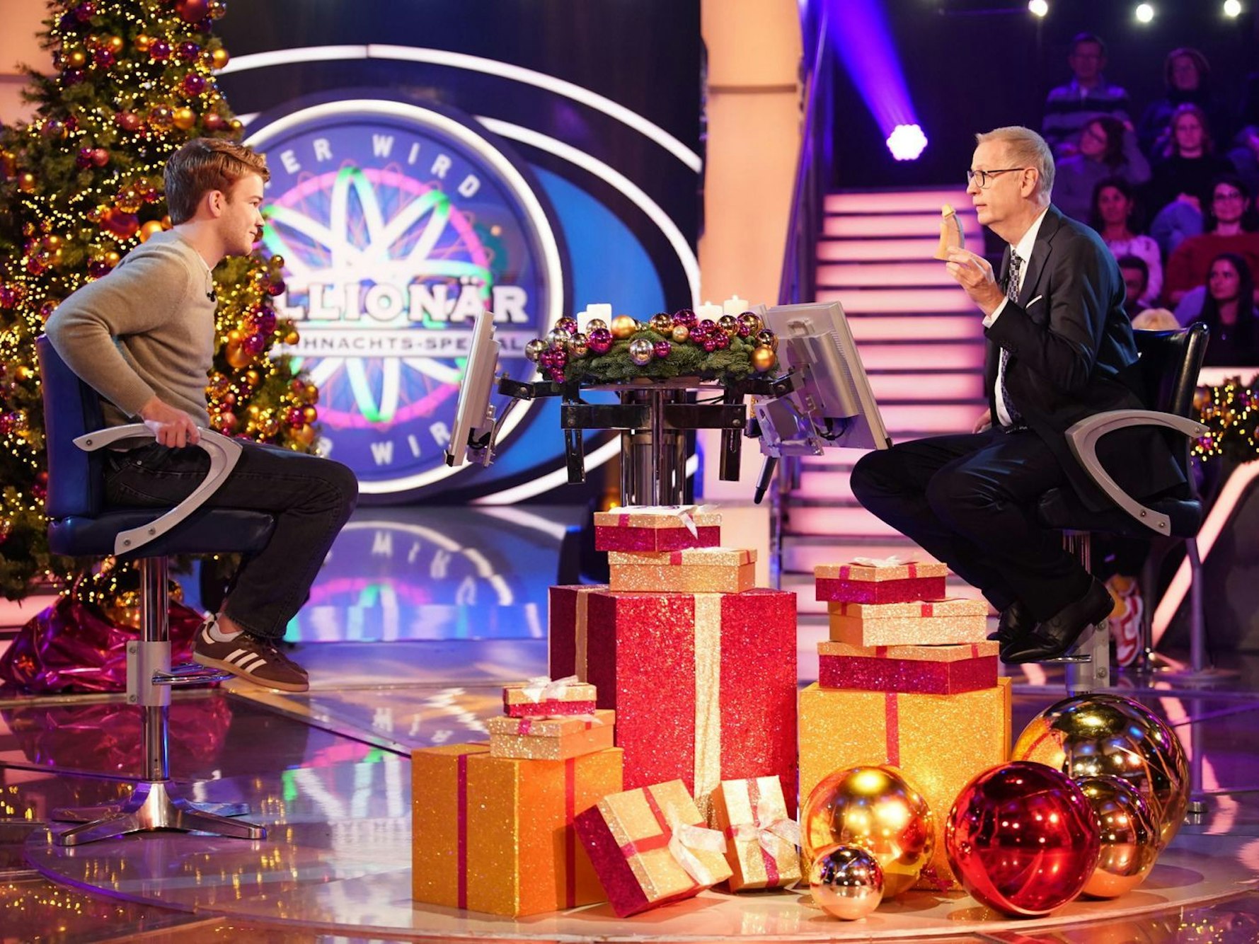 Tom Lorenz sitzt als Kandidat von „Wer wird Millionär?“ am Quizpult gegenüber von Moderator Günther Jauch.