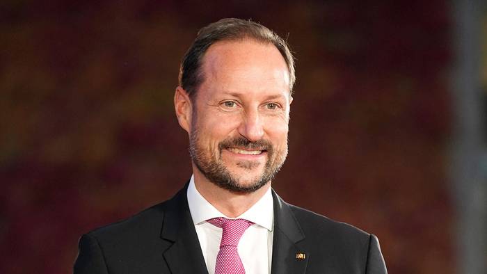 Kronprinz Haakon von Norwegen lächelt in Anzug.