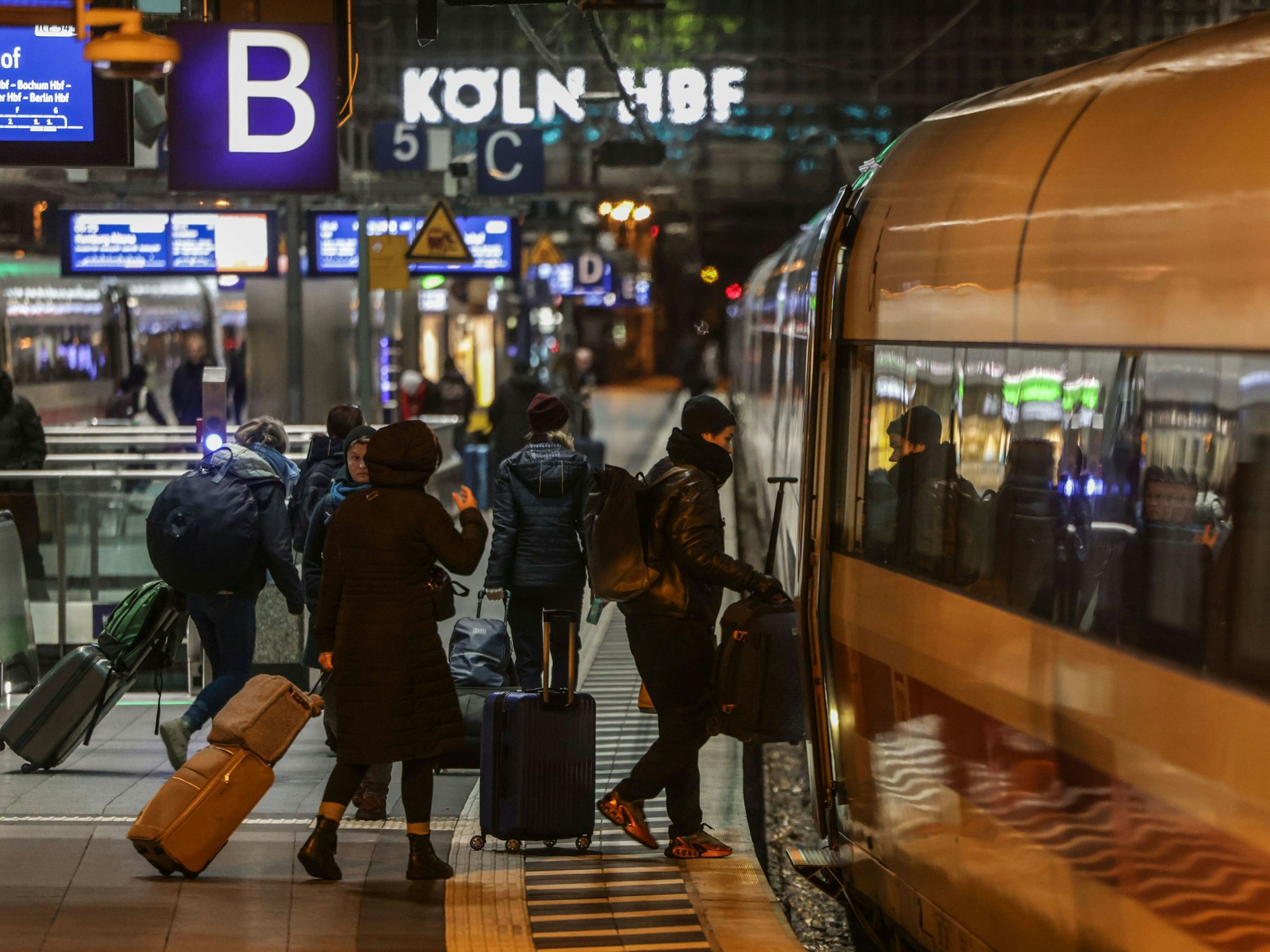Reisende steigen am Kölner Hauptbahnhof in einen ICE der Deutschen Bahn.