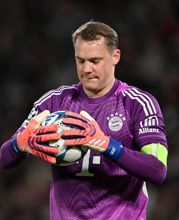 Manuel Neuer hält während eines Spiels einen Ball in beiden Händen.
