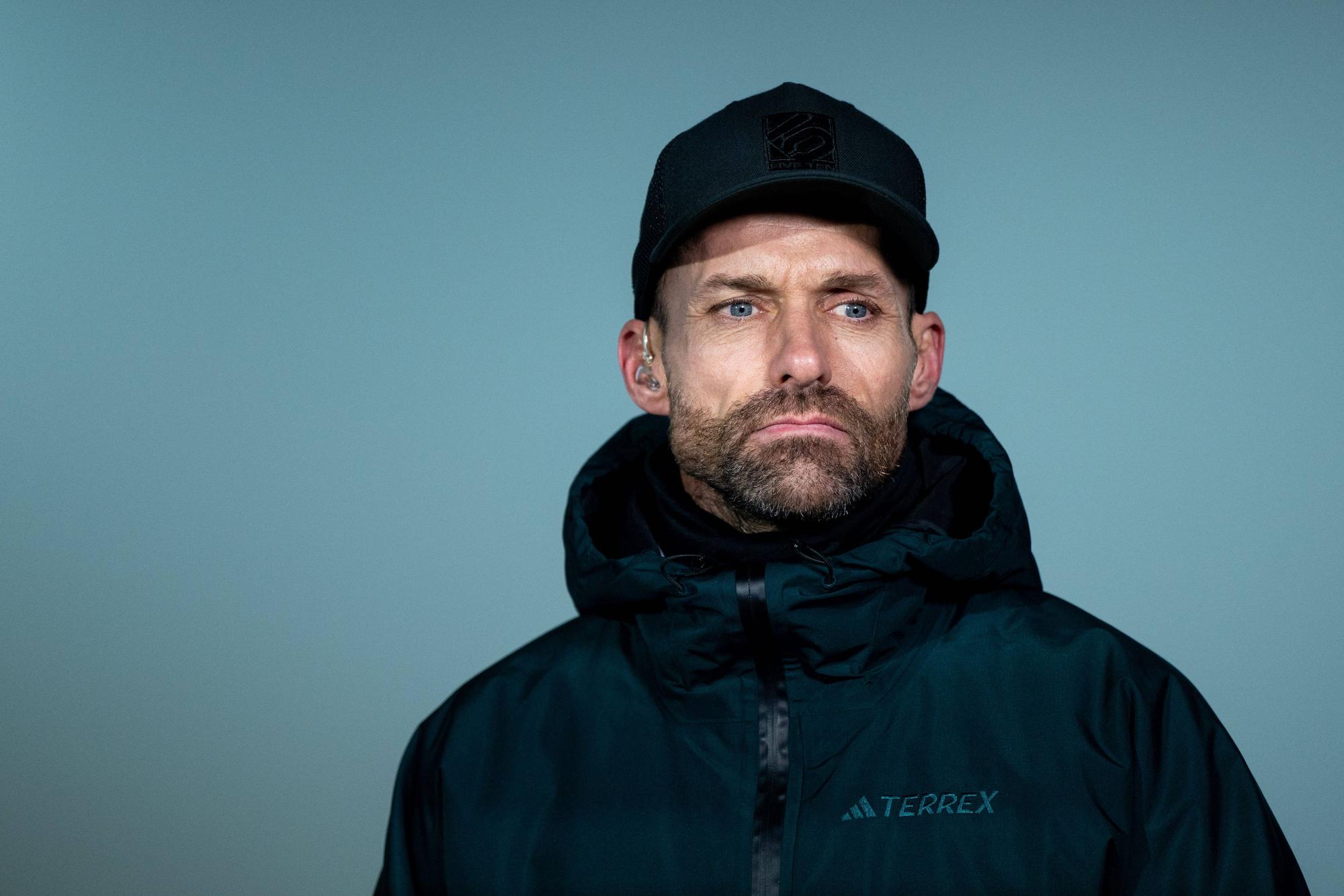 Sven Hannawald guckt ernst. Er trägt eine dunkle Winterjacke und eine Kappe.