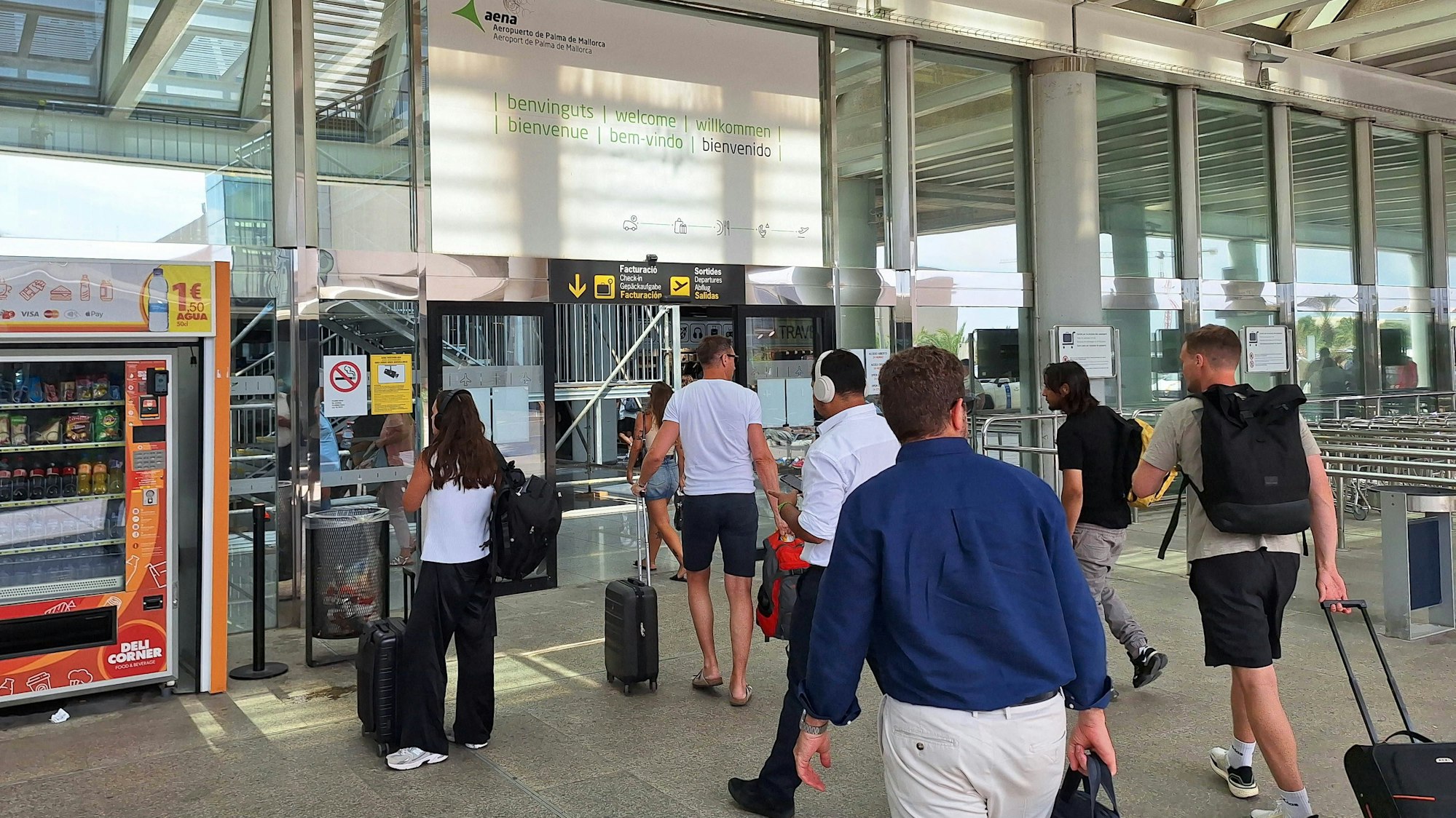 Reisende gehen mit Gepäck durch ein Gebäude