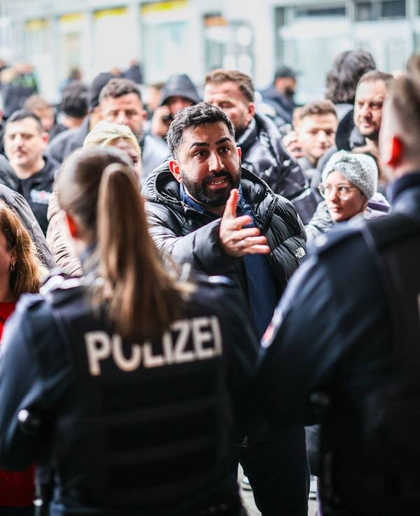 Aufgebrachte Kunden diskutieren vor der Sparkassenfiliale in Buer mit Polizeibeamten nach der Räumung des Vorraums der Filiale.
