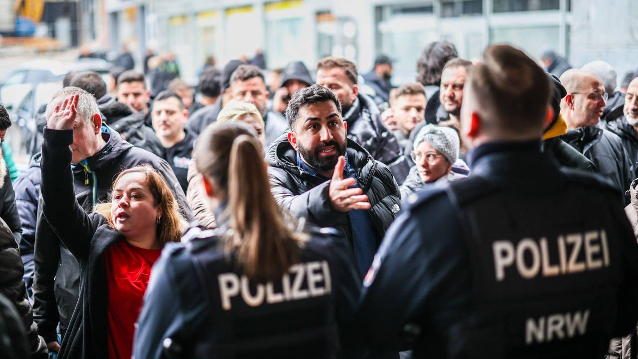 Aufgebrachte Kunden diskutieren vor der Sparkassenfiliale in Buer mit Polizeibeamten nach der Räumung des Vorraums der Filiale.
