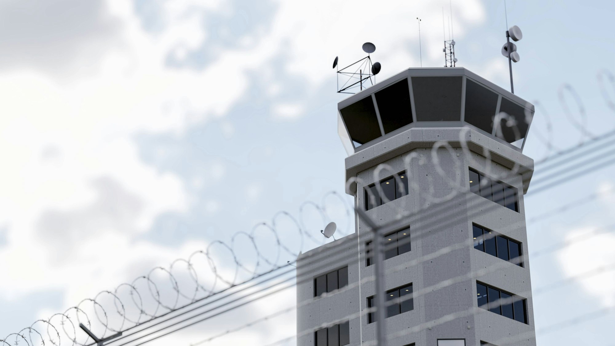Ein Kontrollturm hinter einem Stacheldrahtzaun