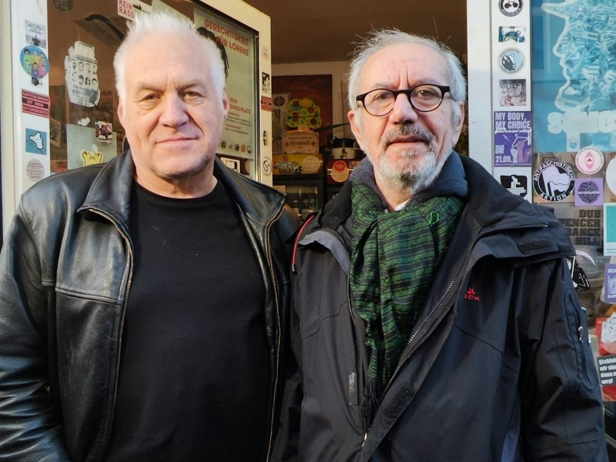 Zwei Männer stehen vor einem Kiosk.