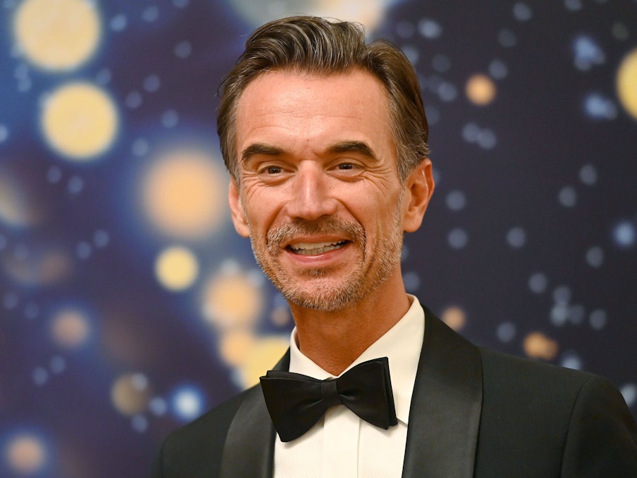 Florian Silbereisen im Anzug vor unscharfem Hintergrund