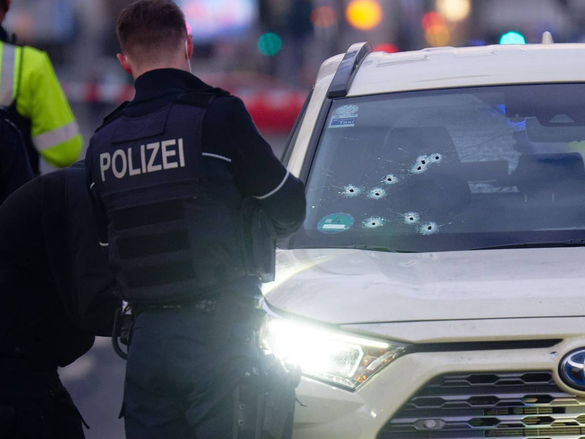 Ein Taxi mit Schusslöchern in der Frontscheibe steht auf der Straße.