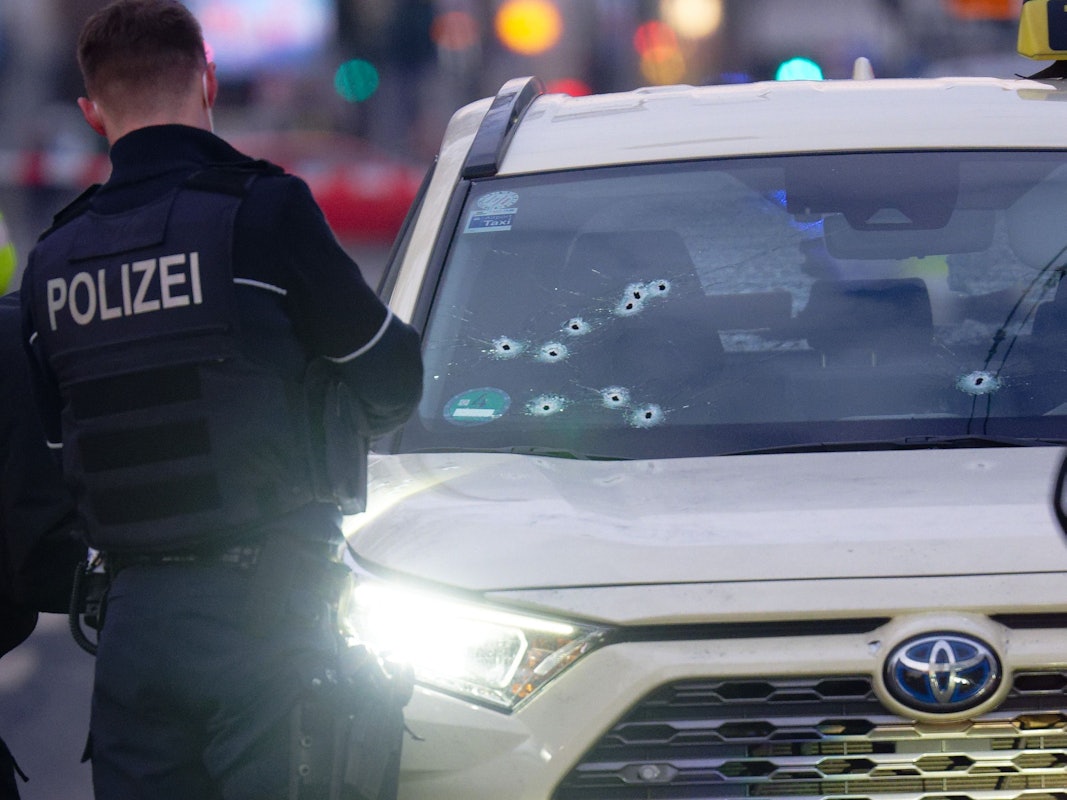 Ein Taxi mit Schusslöchern in der Frontscheibe steht auf der Straße.