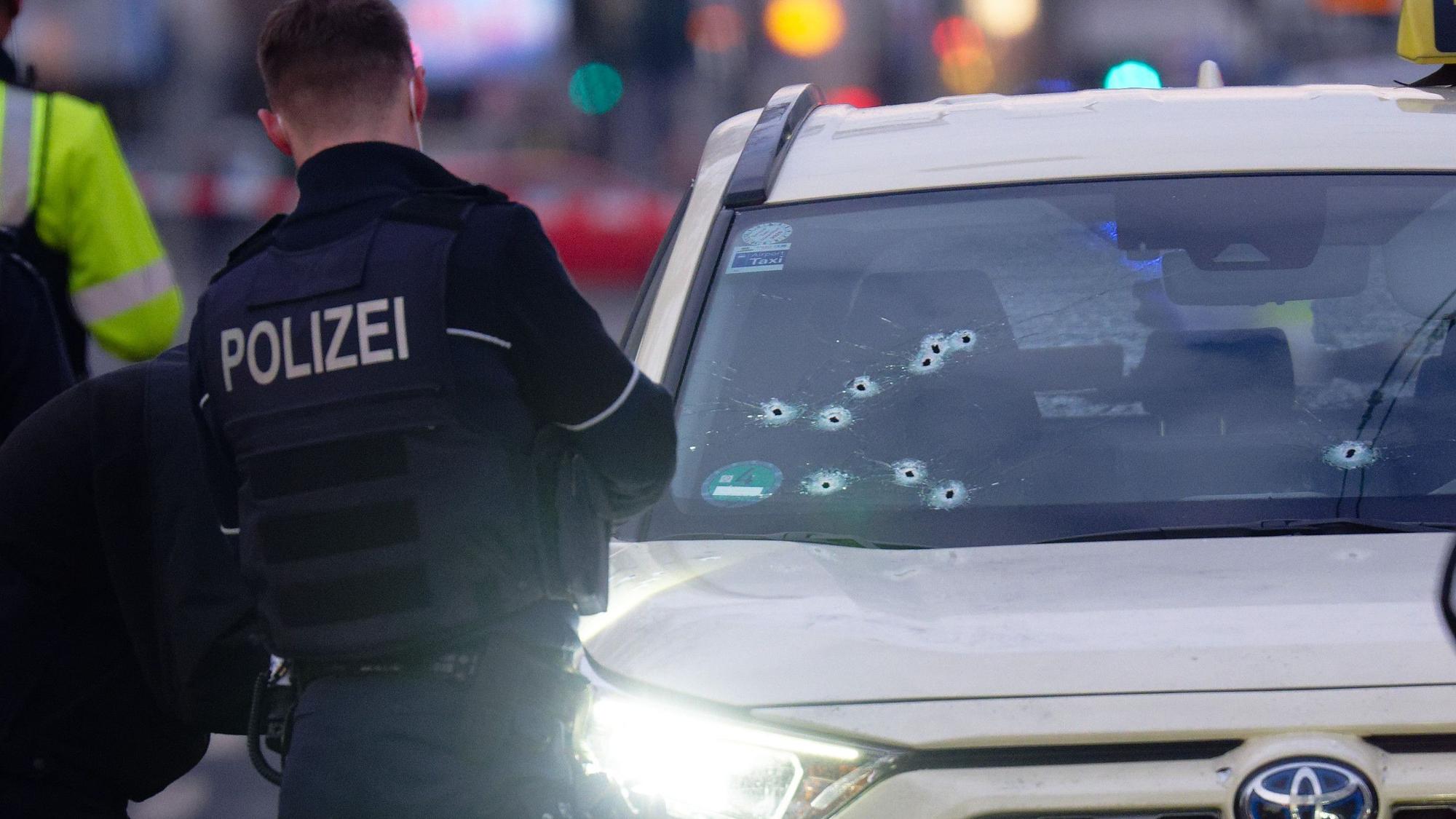 Ein Taxi mit Schusslöchern in der Frontscheibe steht auf der Straße. V