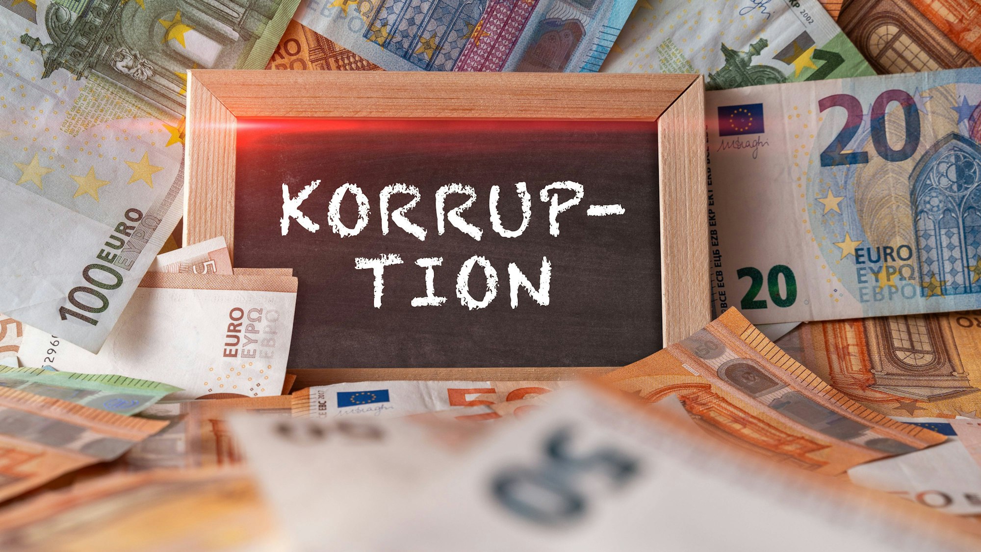 Geldscheine und eine Tafel mit dem Wort Korruption
