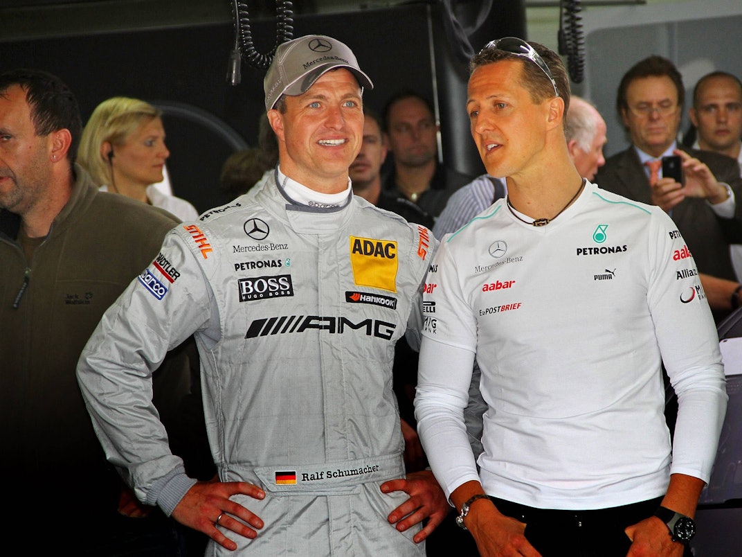 In der Box stehen Ralf und Michael Schumacher bei einem Rennen der DTM nebeneinander.