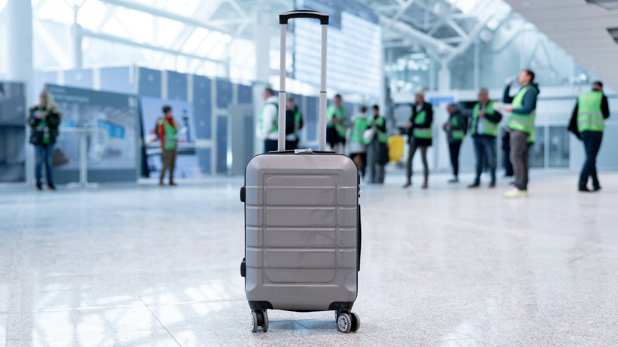 Unbeaufsichtigter Koffer in belebter Flughafenhalle