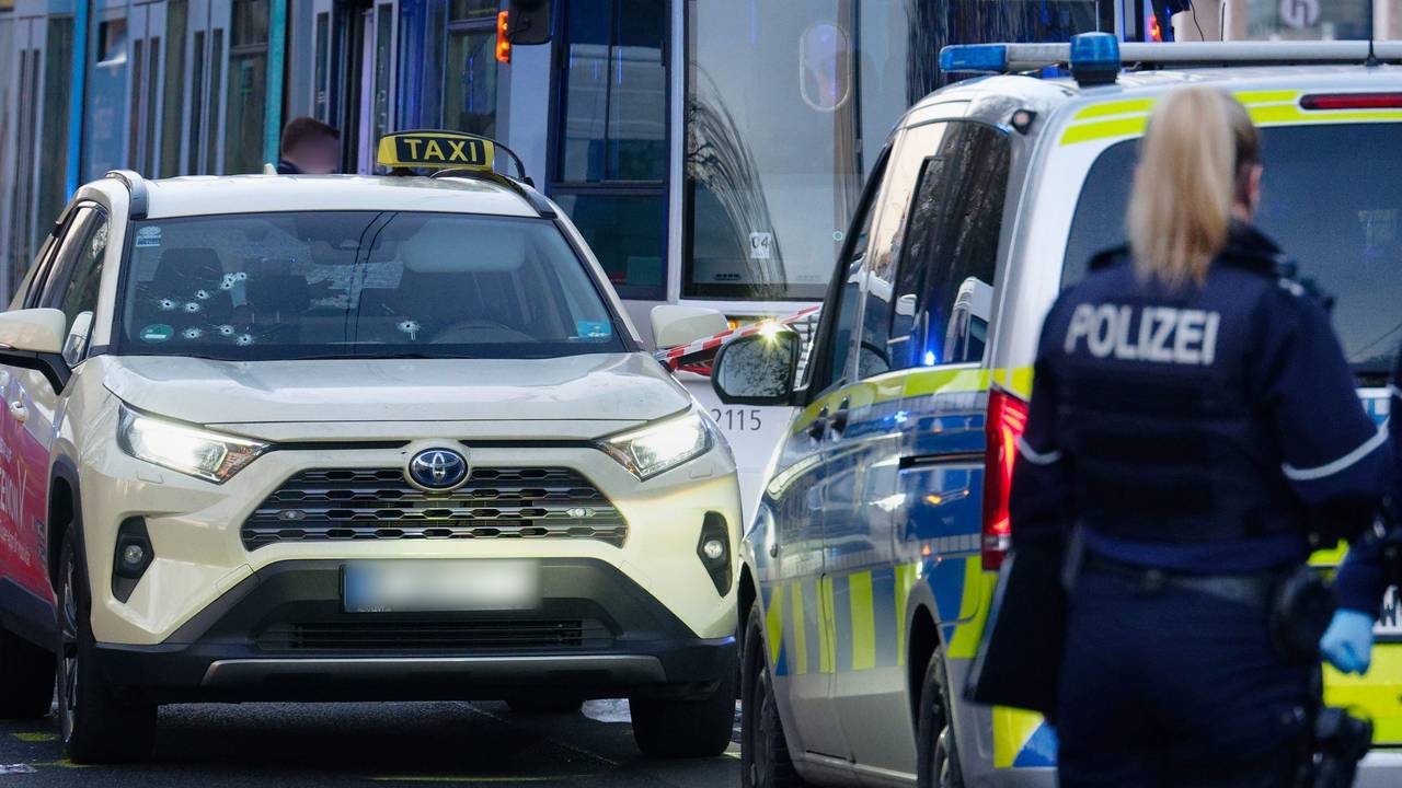 Ein Taxi mit Schusslöchern in der Frontscheibe steht auf der Straße.