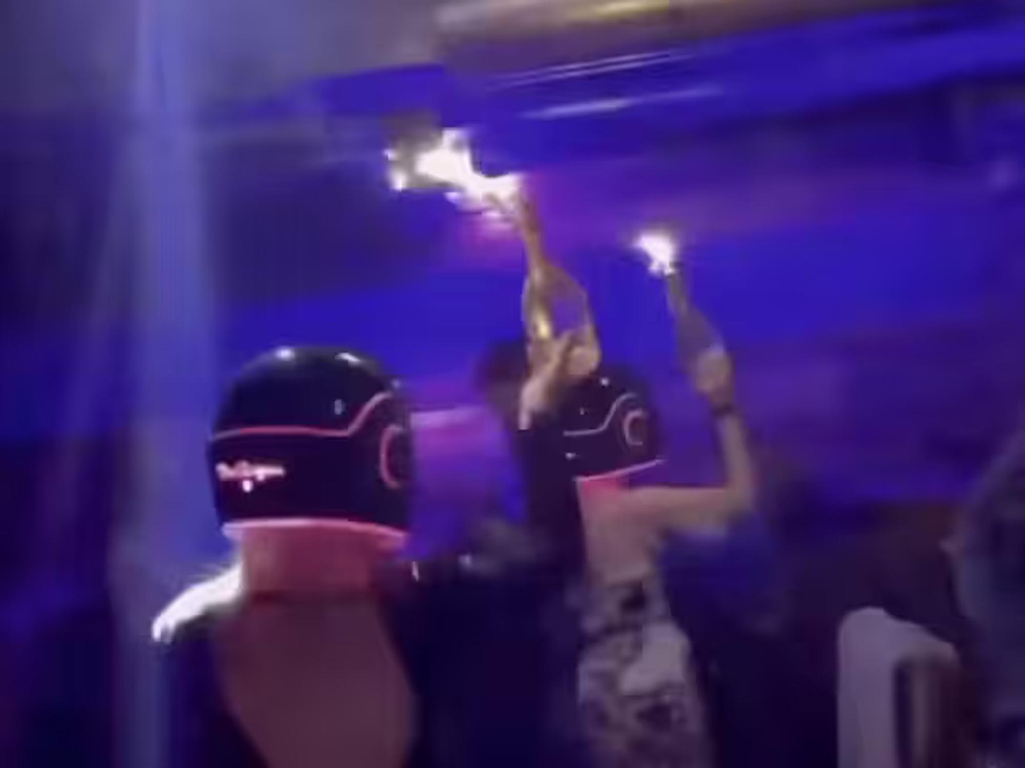 In einem Werbevideo sind Frauen zu sehen, die Champagnerflaschen mit Wunderkerzen in die Höhe halten.