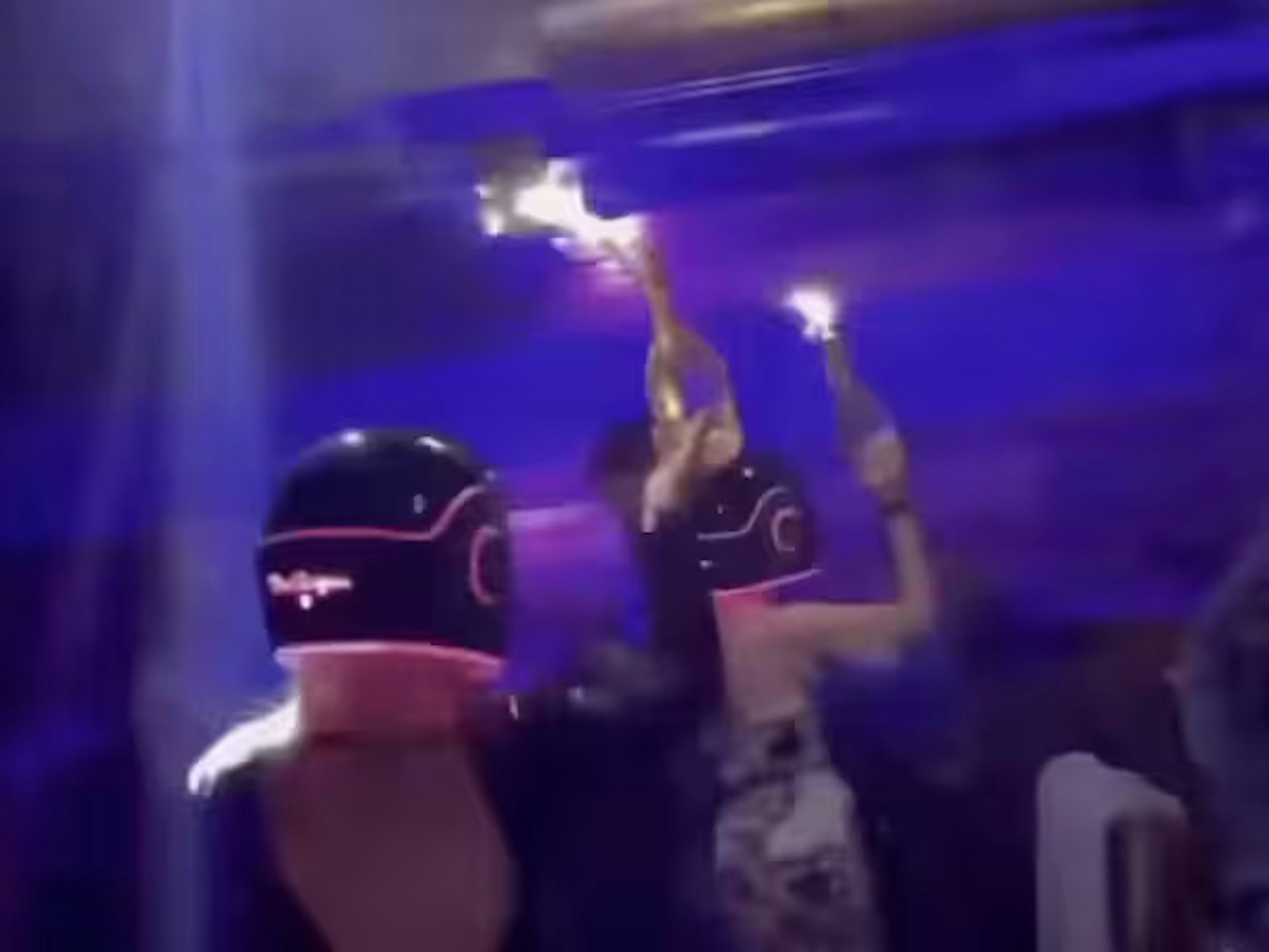 In einem Werbevideo sind Frauen zu sehen, die Champagnerflaschen mit Wunderkerzen in die Höhe halten.