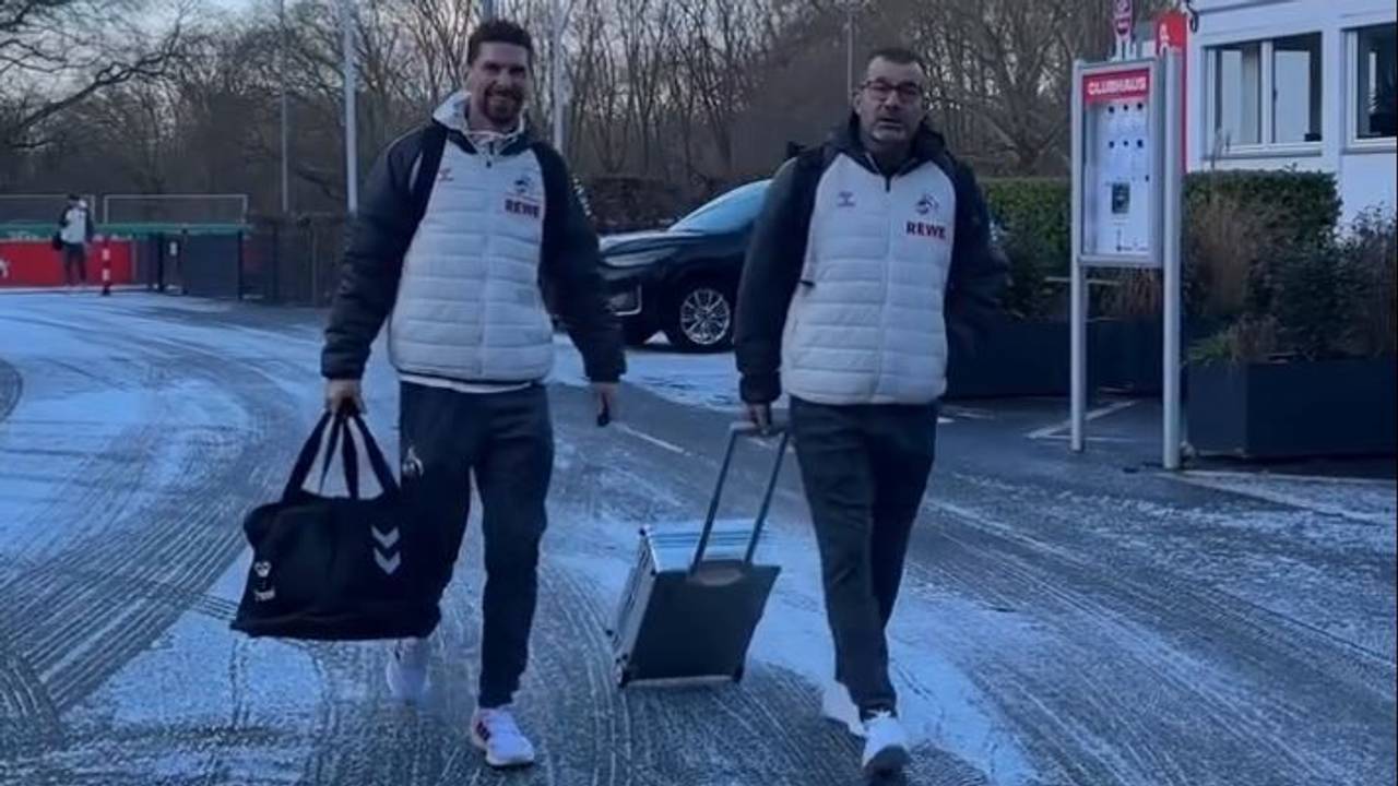 Spieler und Betreuer des 1. FC Köln gehen am Geißbockheim Richtung Mannschaftsbus.