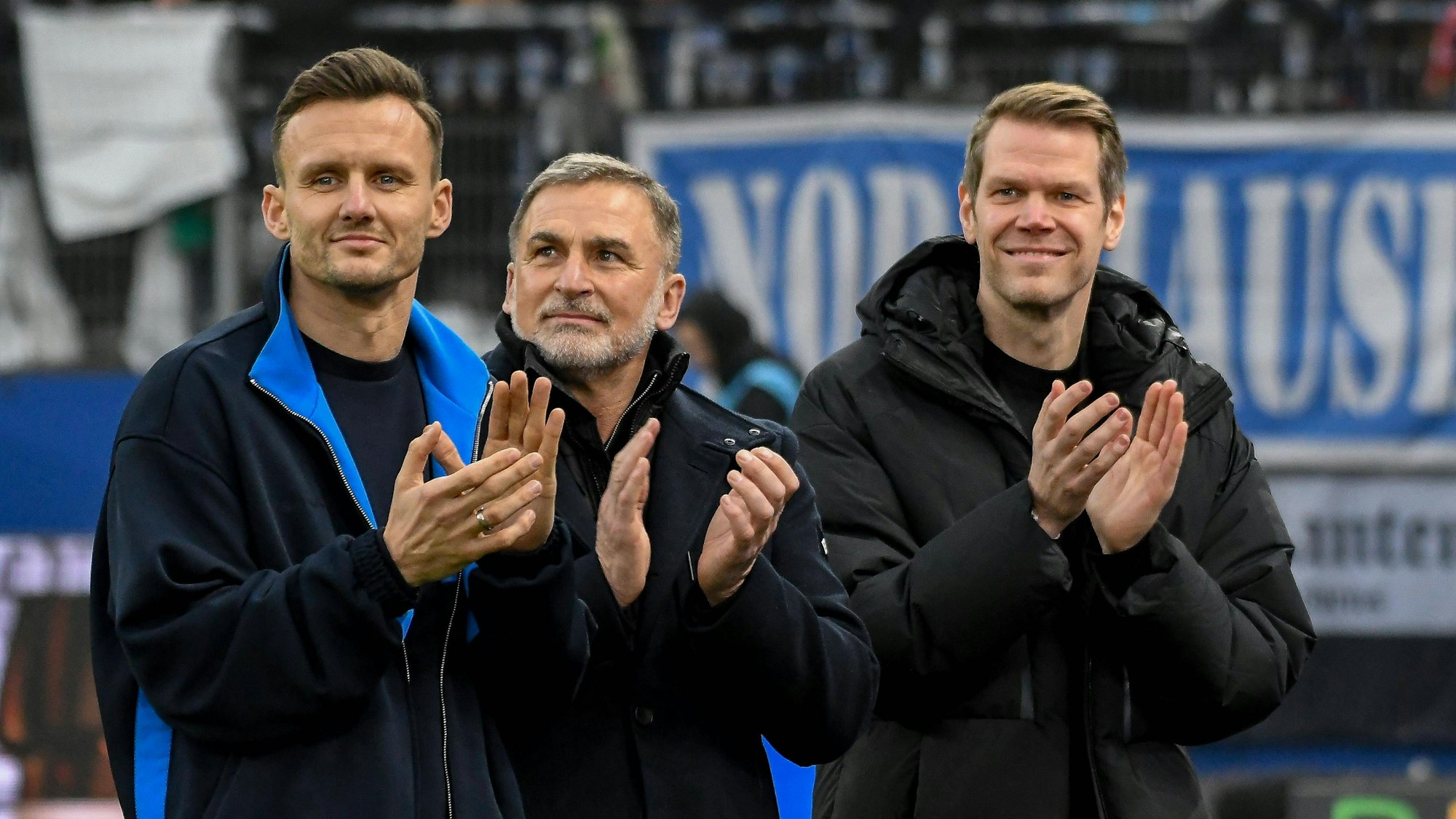 Claus Costa, Stefan Kuntz und Eric Huwer klatschen.