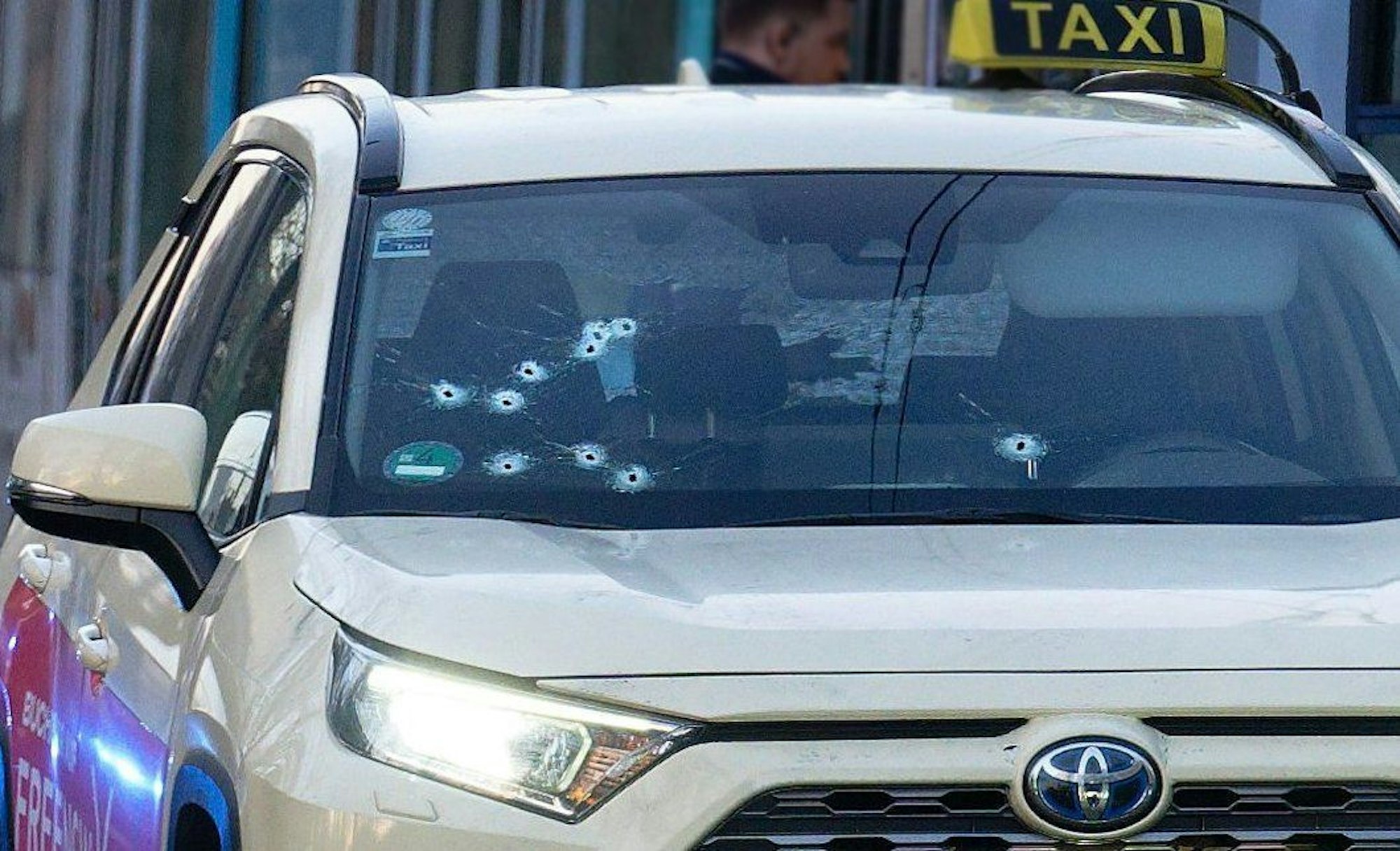 Ein Taxi mit Schusslöchern in der Frontscheibe steht auf der Straße in Düsseldorf.