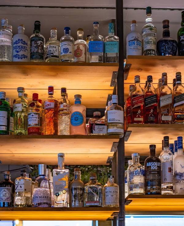 Die Polizei Lübeck prüft derzeit Hinweise, ob es beim Ausschank zu einer Verwechslung von Reinigungsmittel und einem alkoholischen Getränk gekommen sein könnte. Das Symbolfoto zeigt ein Regal mit verschiedenen Flaschen alkoholhaltiger Getränke in einer Bar und steht nicht im direkten Zusammenhang mit dem Timmendorfer Fall.