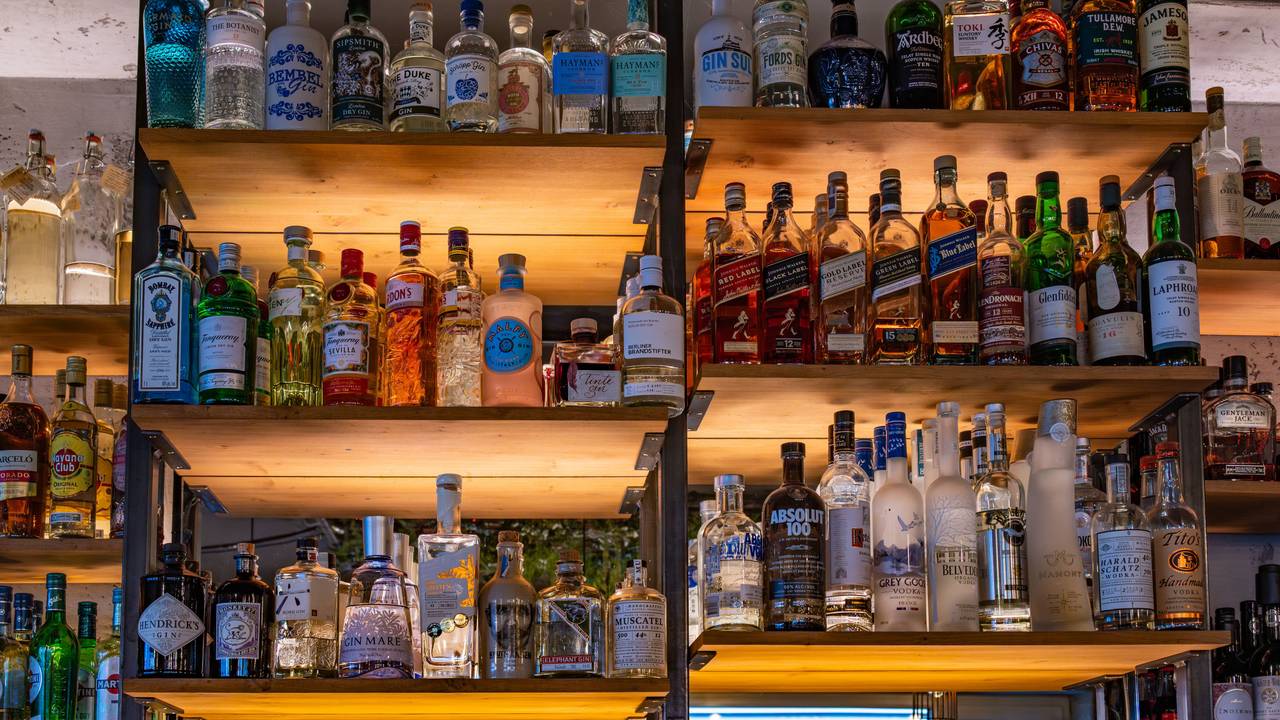Die Polizei Lübeck prüft derzeit Hinweise, ob es beim Ausschank zu einer Verwechslung von Reinigungsmittel und einem alkoholischen Getränk gekommen sein könnte. Das Symbolfoto zeigt ein Regal mit verschiedenen Flaschen alkoholhaltiger Getränke in einer Bar und steht nicht im direkten Zusammenhang mit dem Timmendorfer Fall.